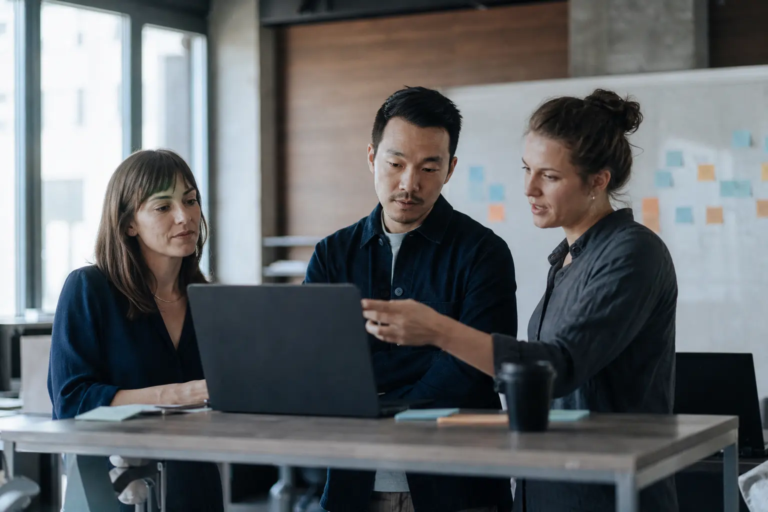 A team working through a problem at a shared desk